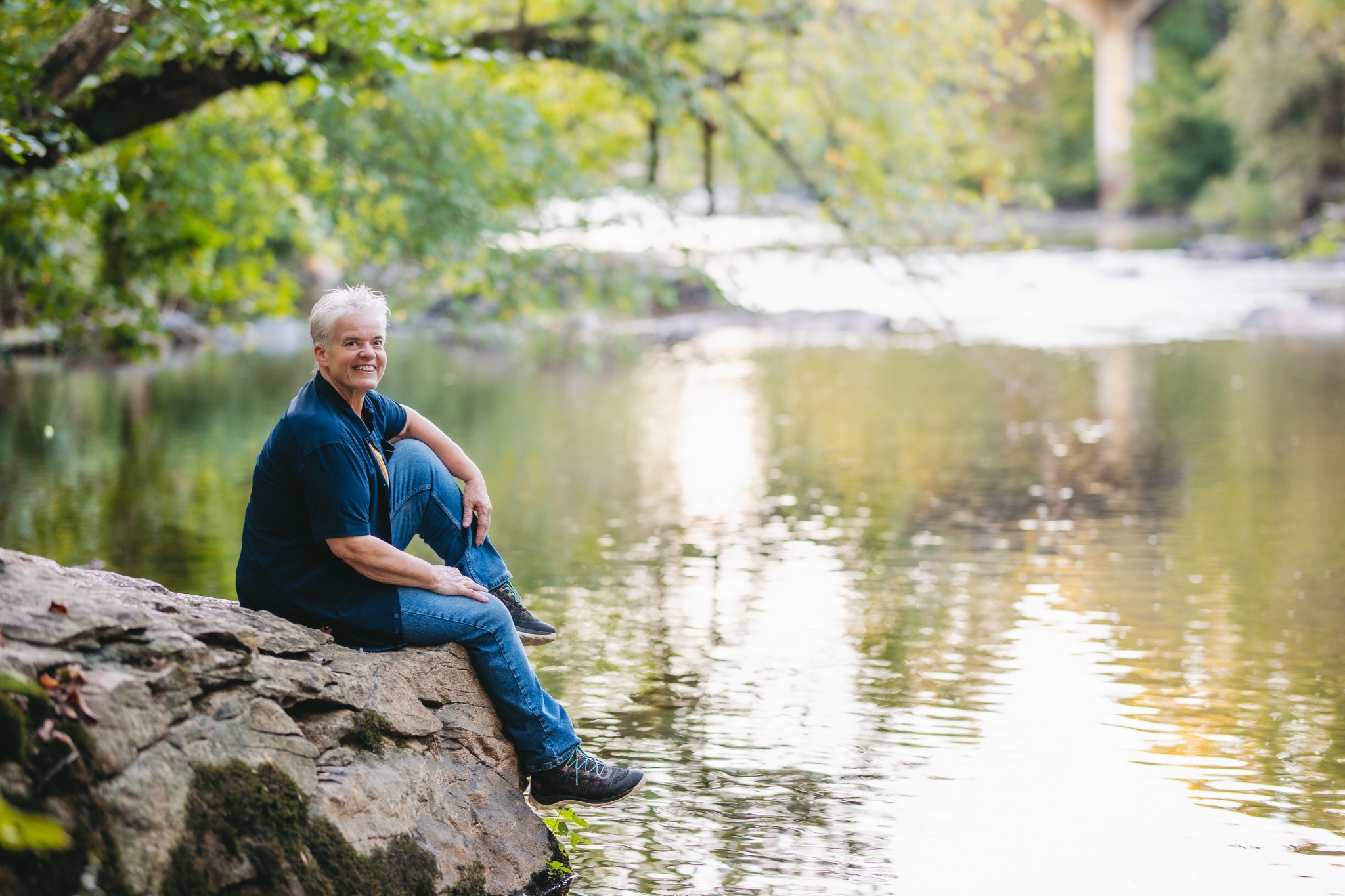 Deana Coble sitting beside a peaceful river